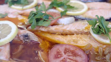 close-up of a delicious salmon dish with lemon slices, tomatoes, and parsley