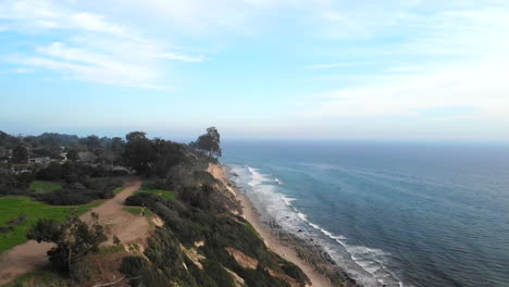 Un-Dron-Aéreo-Disparó-Sobre-Los-Acantilados-De-La-Playa-De-La-Reserva-De-Douglas-En-Santa-Barbara,-Californai,-Con-Las-Olas-Azules-Del-Océano-Rompiendo-Debajo