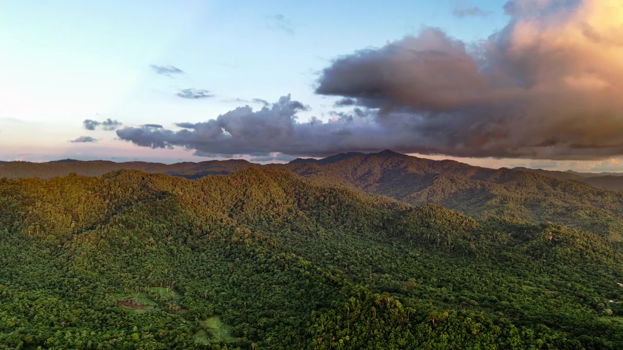 Vista aerea con drone di ampie creste montuose coperte dalla giungla che si estendono fino all'orizzonte sotto un cielo serale parzialmente nuvoloso, Barotuan, El Nido, Palawan, Filippine
