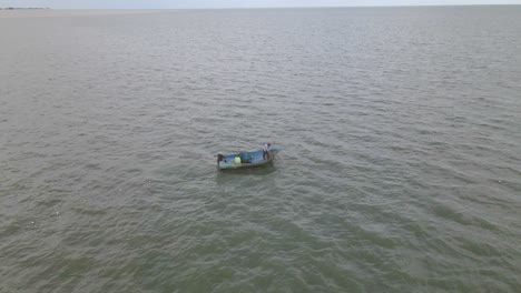 4K-Aerial-Drone-Footage-of-a-Fisherman-in-a-Wooden-Boat-Pulling-in-a-Net-from-Above-in-Thailand