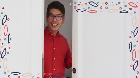 animation of colourful patterned frame over smiling asian man in glasses welcoming at front door