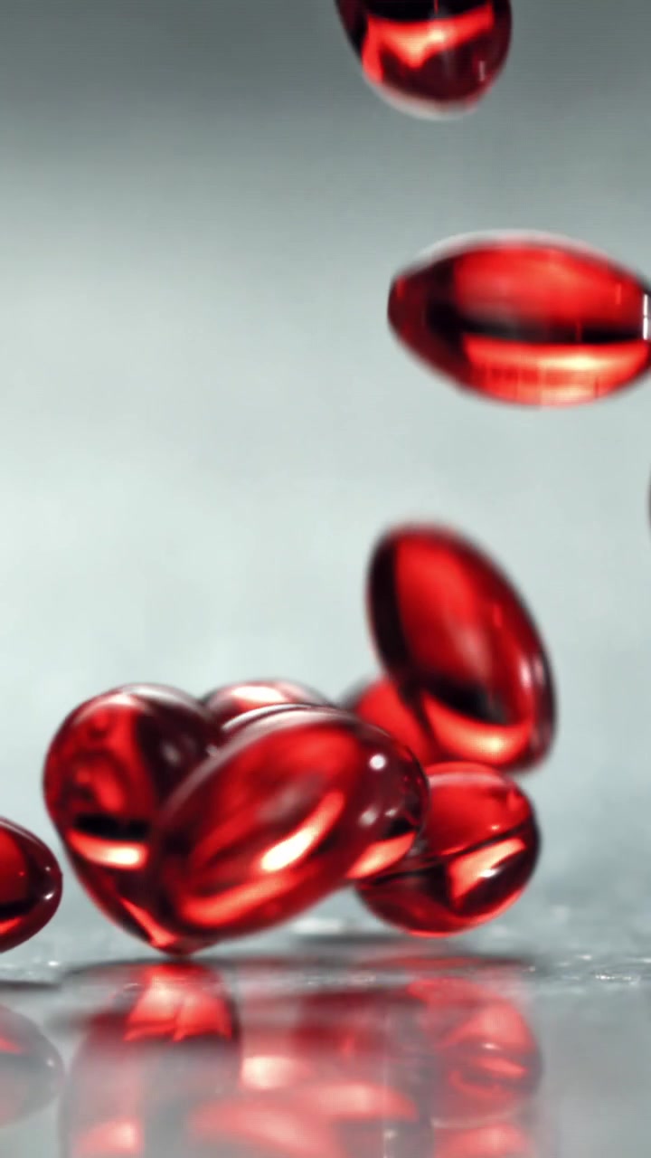 Capsule di gel rosse che cadono e rimbalzano al rallentatore