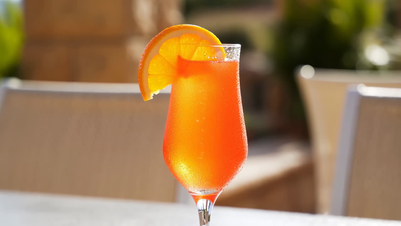 Cocktail rinfrescante all'arancia con guarnizione di agrumi su un patio soleggiato