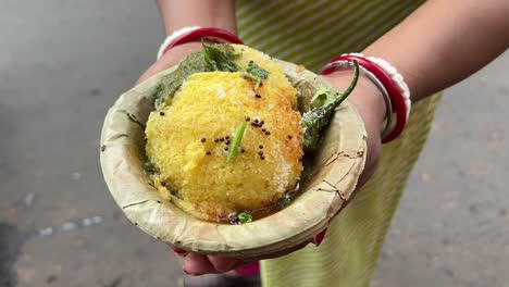 indian gujarati traditional dish green peas dhokhla held by an indian girl