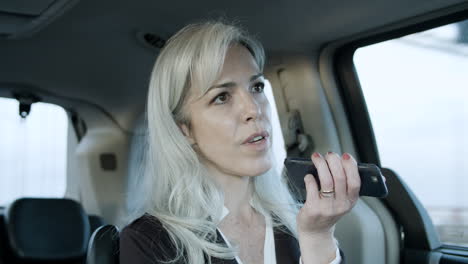 business woman recording voice message in a car