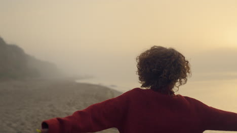 excited girl jumping on beach. smiling woman turning around on sea coast