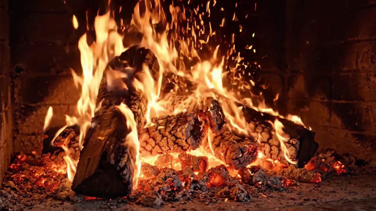 Fiamme affascinanti danzano tra i ceppi scoppiettanti in un accogliente camino, avvolgendo la stanza di calore e luce e creando un'atmosfera dinamica e tremolante