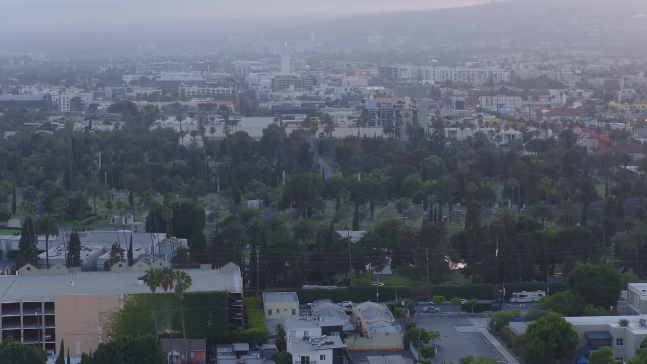 Telephoto dolly aerial shot of historic Hollywood Forever Cemetery at sunset in Los Angeles, California. 4K
