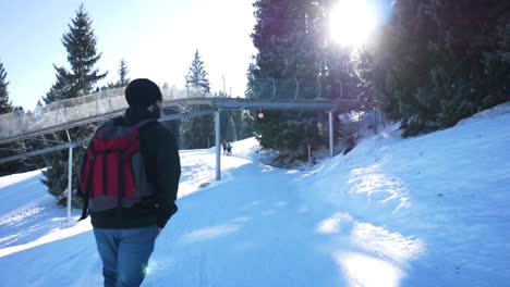 camera follows a young man with winter clothes from the back