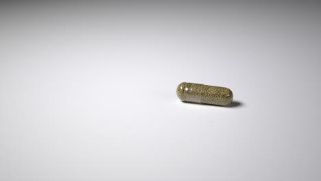 panning to single capsule full of ground cannabis. room for copy on left.