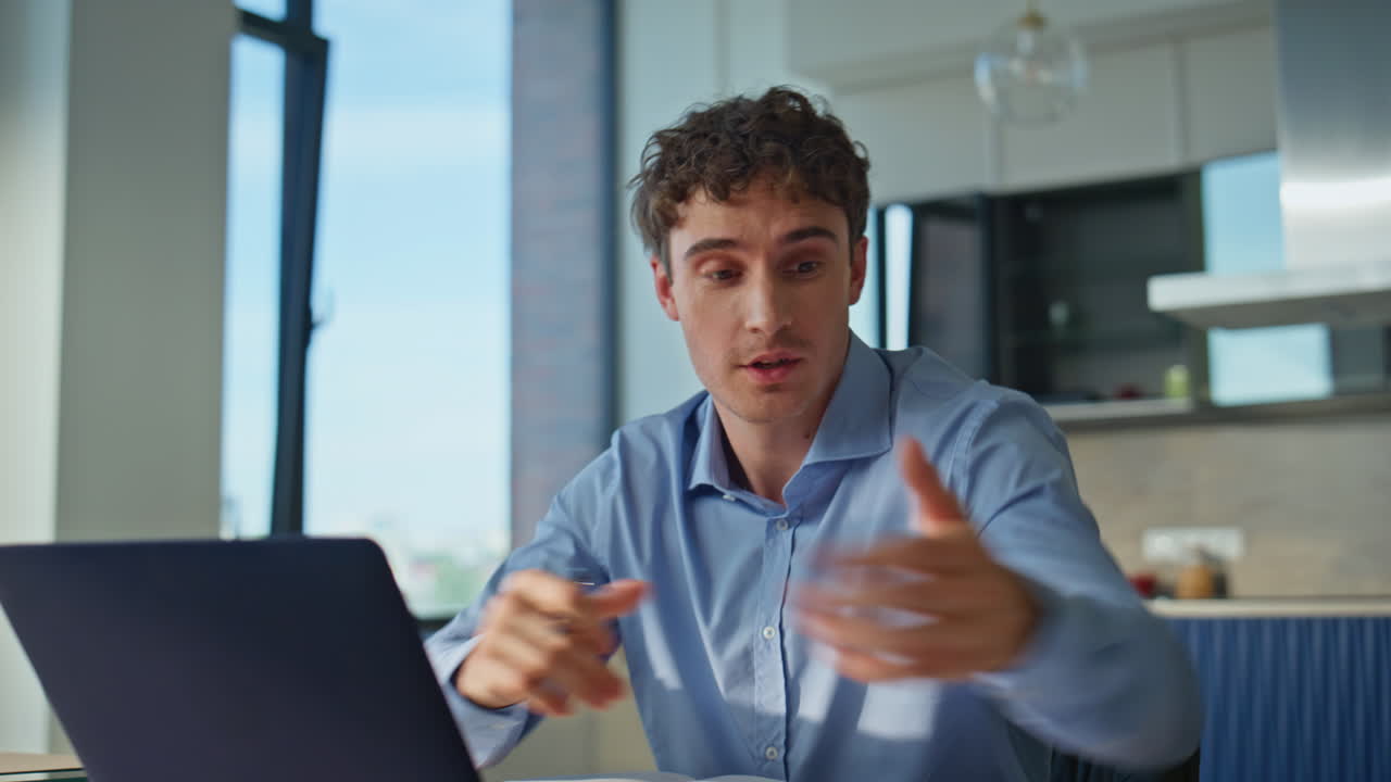 Smiling businessman talking online meeting in modern home office closeup