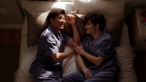 two men in pajamas in bed