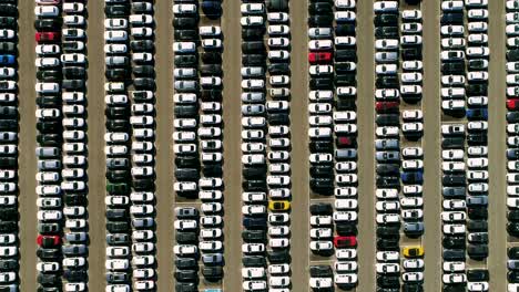 aerial footage of finished cars ready to be shipped on huge distribution center