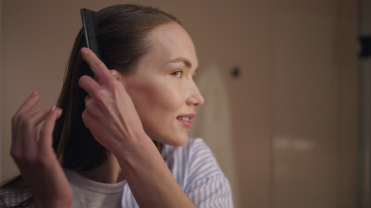 Fashion girl styling hair preparing for date closeup. Attractive lady combing