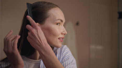 fashion girl styling hair preparing for date closeup. attractive lady combing