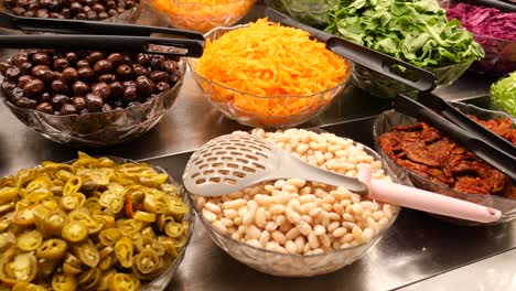 una barra de ensalada con una variedad de ingredientes frescos