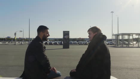 two men talking at airport parking lot