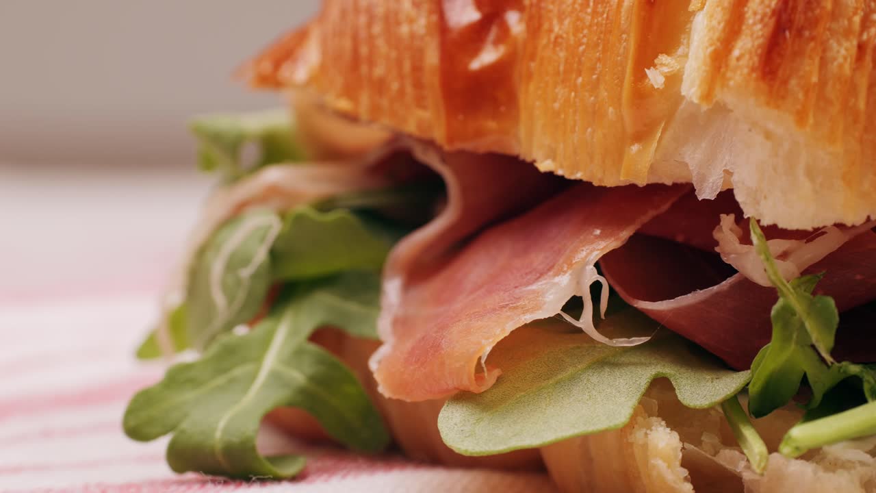 Croissant with jamon ham, Salmon, in Modern Cafe, Top View of Healthy Breakfast in Cafe. English breakfast: fried egg, bacon toast on sandwich.