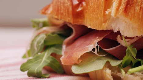 croissant with jamon ham, salmon, in modern cafe, top view of healthy breakfast in cafe. english breakfast: fried egg, bacon toast on sandwich.
