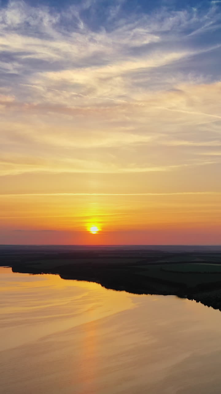 Aerial view of huge river against sunset. Aerial view of landscape of rural countryside at sunset Vertical video