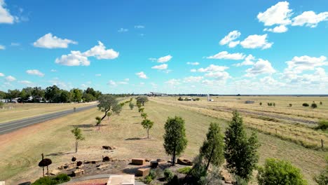 drone footage of the historic welcome to longreach sign rising to show the town in the distance