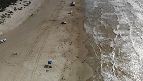 going down the beach, angled with of the beach and ocean with no skyline visible