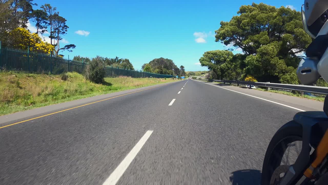 Front wheel POV as touring motorcycle rides on picturesque highway