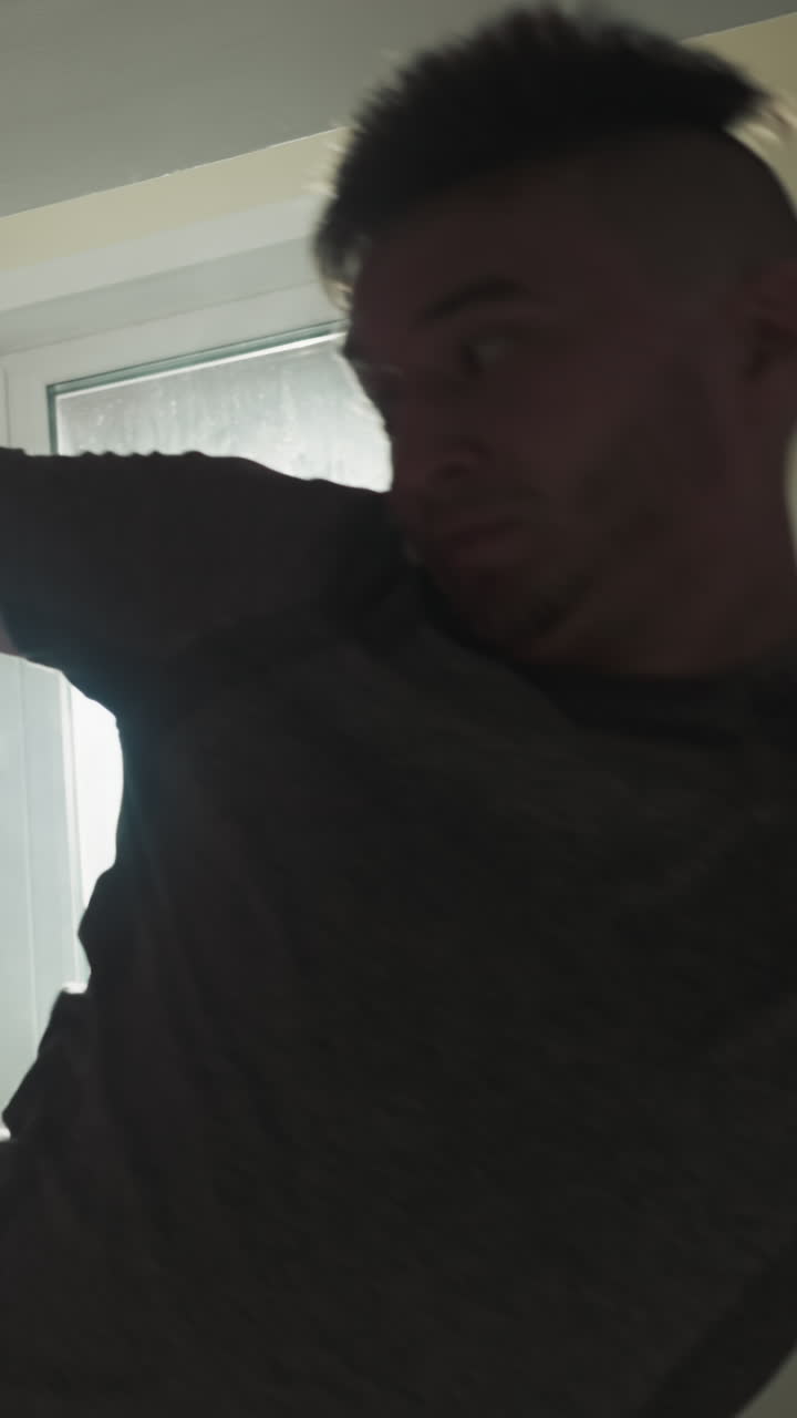 un estudiante de taekwondo ataca una bolsa de boxeo con la pierna en un club deportivo. un joven deportista patea el equipo en el gimnasio en la ventana trasera. luz en cámara lenta. cuerpo y mente fuertes.