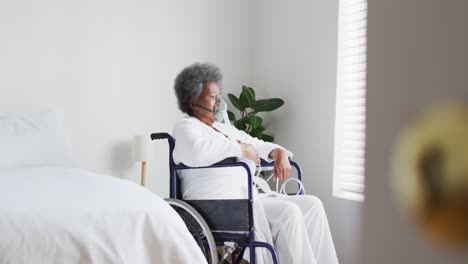 african american senior woman breathing using an oxygen mask at home