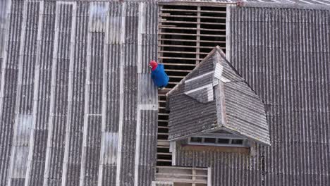 trabajador reparando techo con sellador cerca de mansard, vista aérea hacia abajo