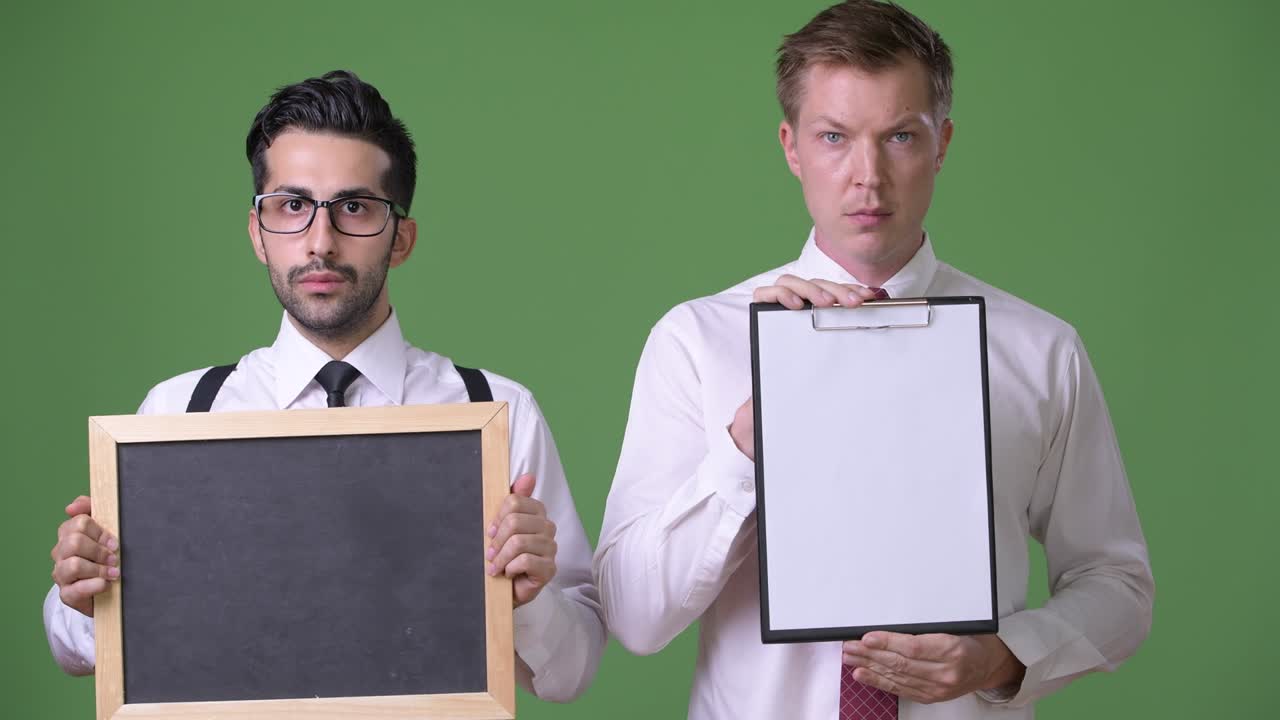 초록색 배경에서 함께 일하는 두 명의 젊은 다민족 사업가