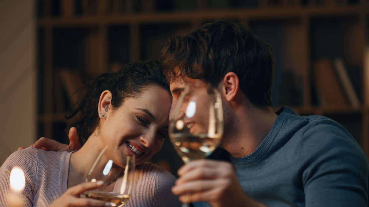 부부가 웃고, 집에서 와인을 마시며 만적인 데이트를 하고, 사랑하는 배우자.