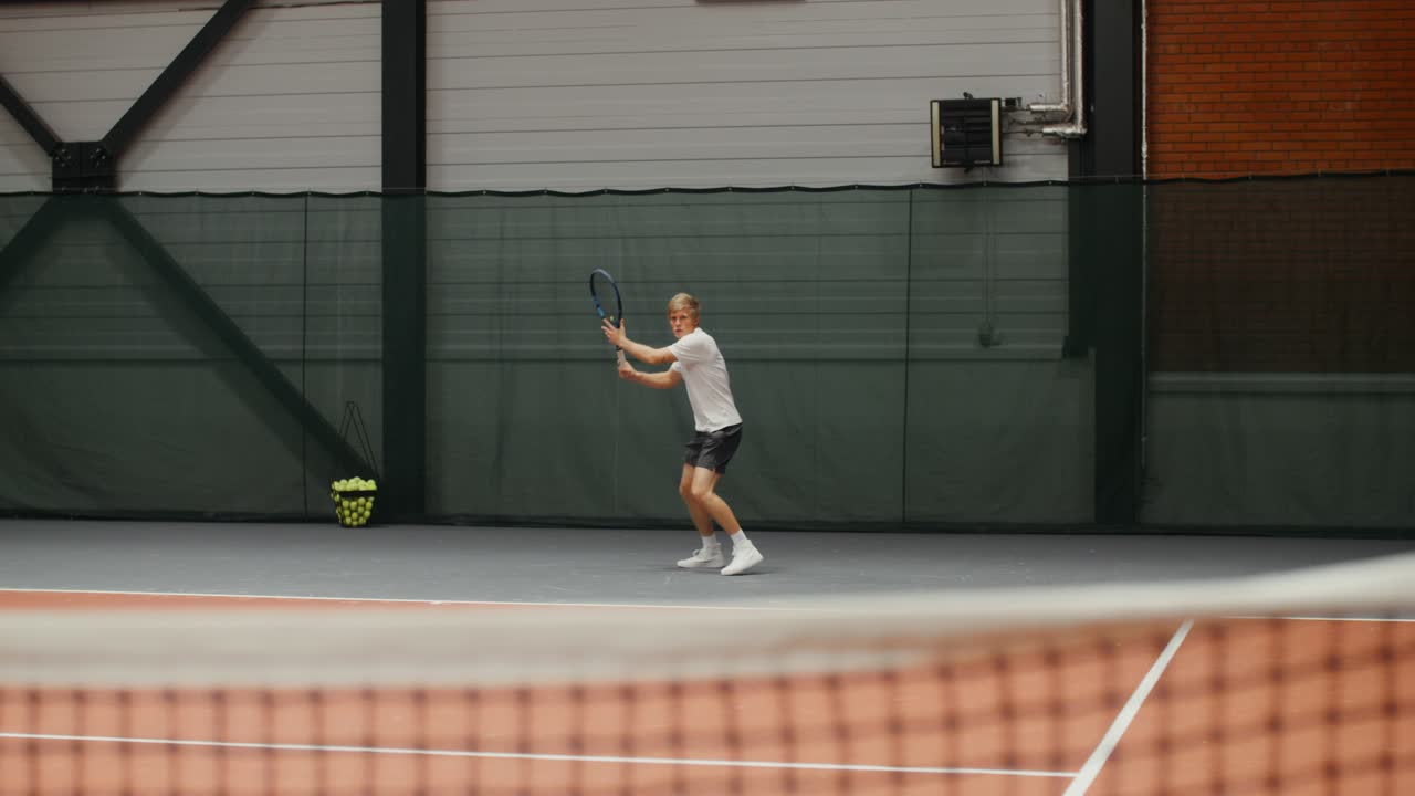 실내에서 테니스를 하는 남자