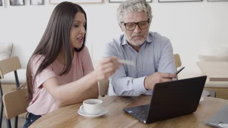 socios profesionales discutiendo proyectos y señalando con bolígrafo