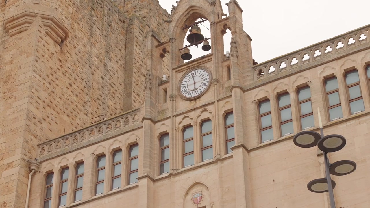The ornate clock tower and bells of the Palace of the Archbishops in Narbonne, France, are captured in this architectural close-up. Ideal for history documentaries or travel features.