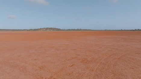 Drone-clip-of-burnt-orange-Australian-outback-desert,-contrasting-against-blue-sky