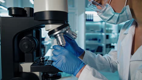 científico que trabaja con el microscopio en un laboratorio