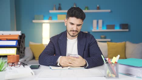 Businessman-looking-at-his-earned-money-and-doing-calculations.