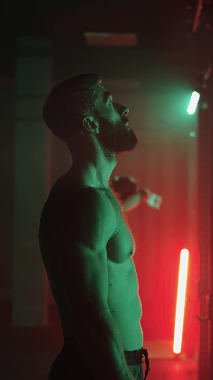 Uomo e donna in forma in piedi in una palestra illuminata al neon suggestiva