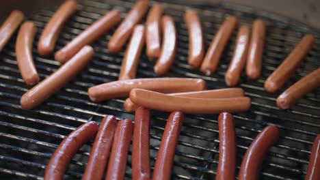 Closeup-shot-of-grilling-sausages-or-hot-dogs-in-smkoer