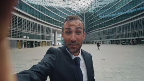 toma cinematográfica de un hombre de negocios haciendo una llamada de video de tecnología a socios o colegas antes de reunirse en el fondo de los rascacielos de la oficina. concepto de red, conexión, comunicación, éxito, internet.