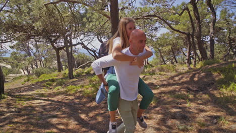 Man-piggybacking-girlfriend-in-forest