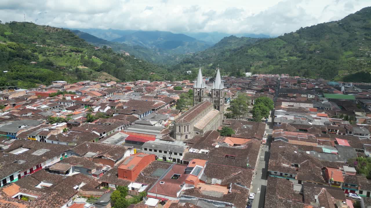 Aerial drone footage of the picturesque church Basílica Menor de la Inmaculada Concepción and the central square in the Andean town of Jardín in Colombia