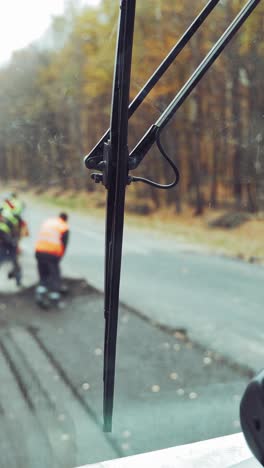 worker operating asphalt paver machine during road construction