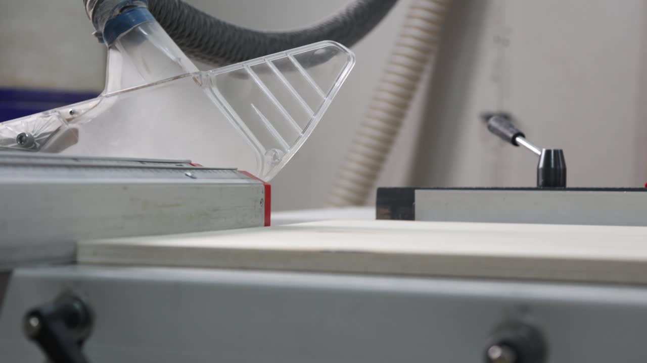 Process of cutting wood with a desktop circular saw in a carpentry workshop