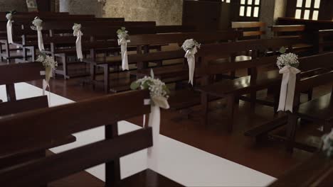 wedding church interior decor with flowers and ribbons on wooden benches