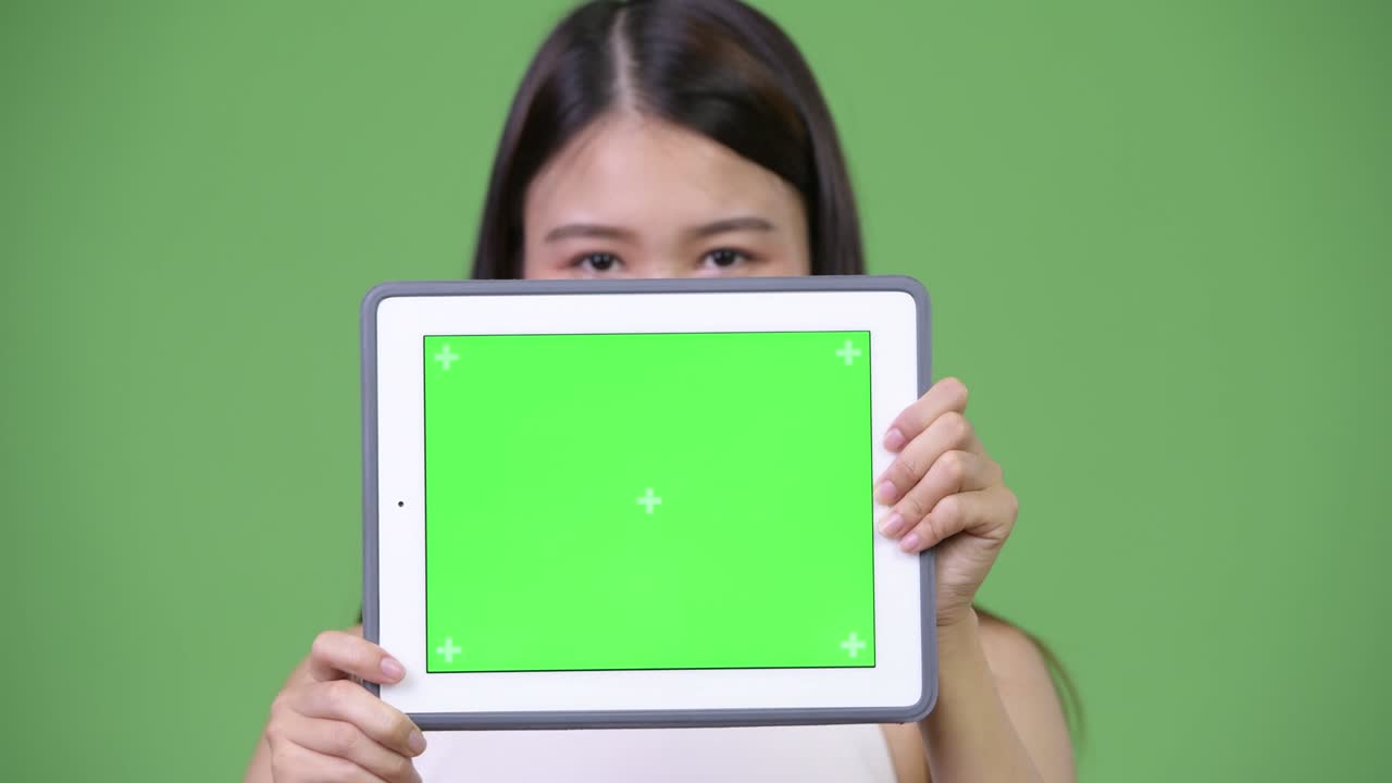 젊은 아름다운 아시아 사업가 여성이 디지털 태블릿을 보여줍니다.