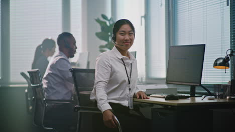 smiling asian woman customer service representative at desk