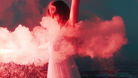 woman waving flare dancing on beach at dawn burning distress signal firework