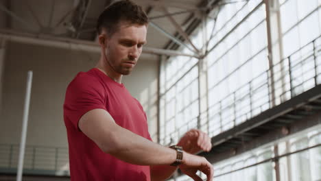man checking smartwatch at gym
